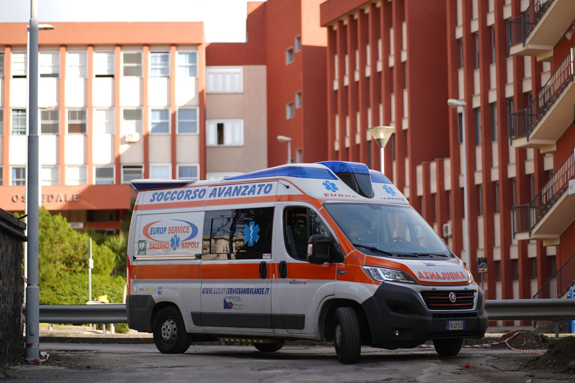 Un'ambulanza è parcheggiata davanti a un edificio in mattoni rossi in una strada cittadina.