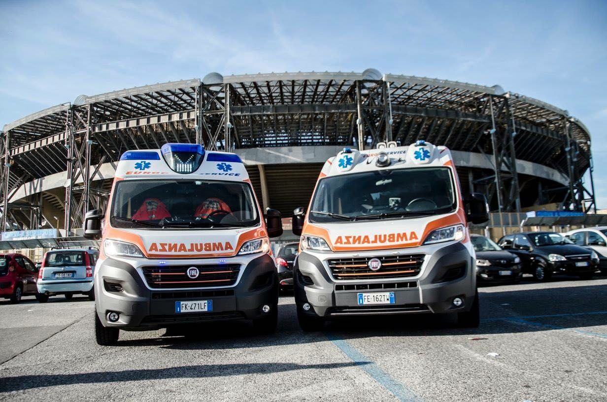 Due ambulanze parcheggiate davanti a uno stadio