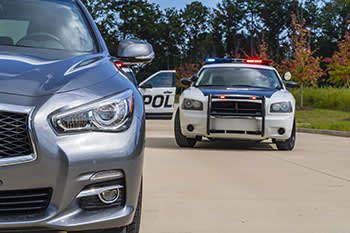 a police car is following a car on the road .