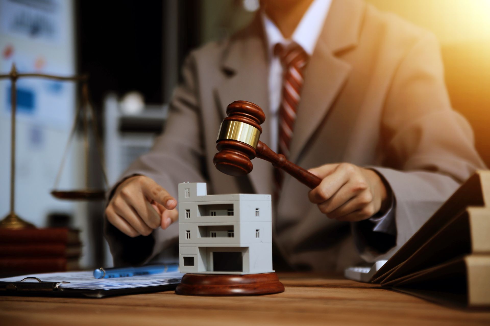 a wooden house is sitting on a wooden table next to a wooden gavel .