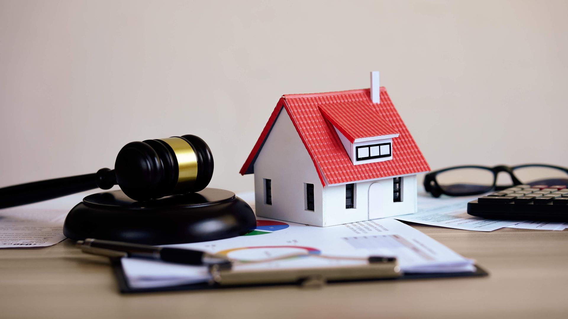 a wooden house is sitting on a wooden table next to a wooden gavel .
