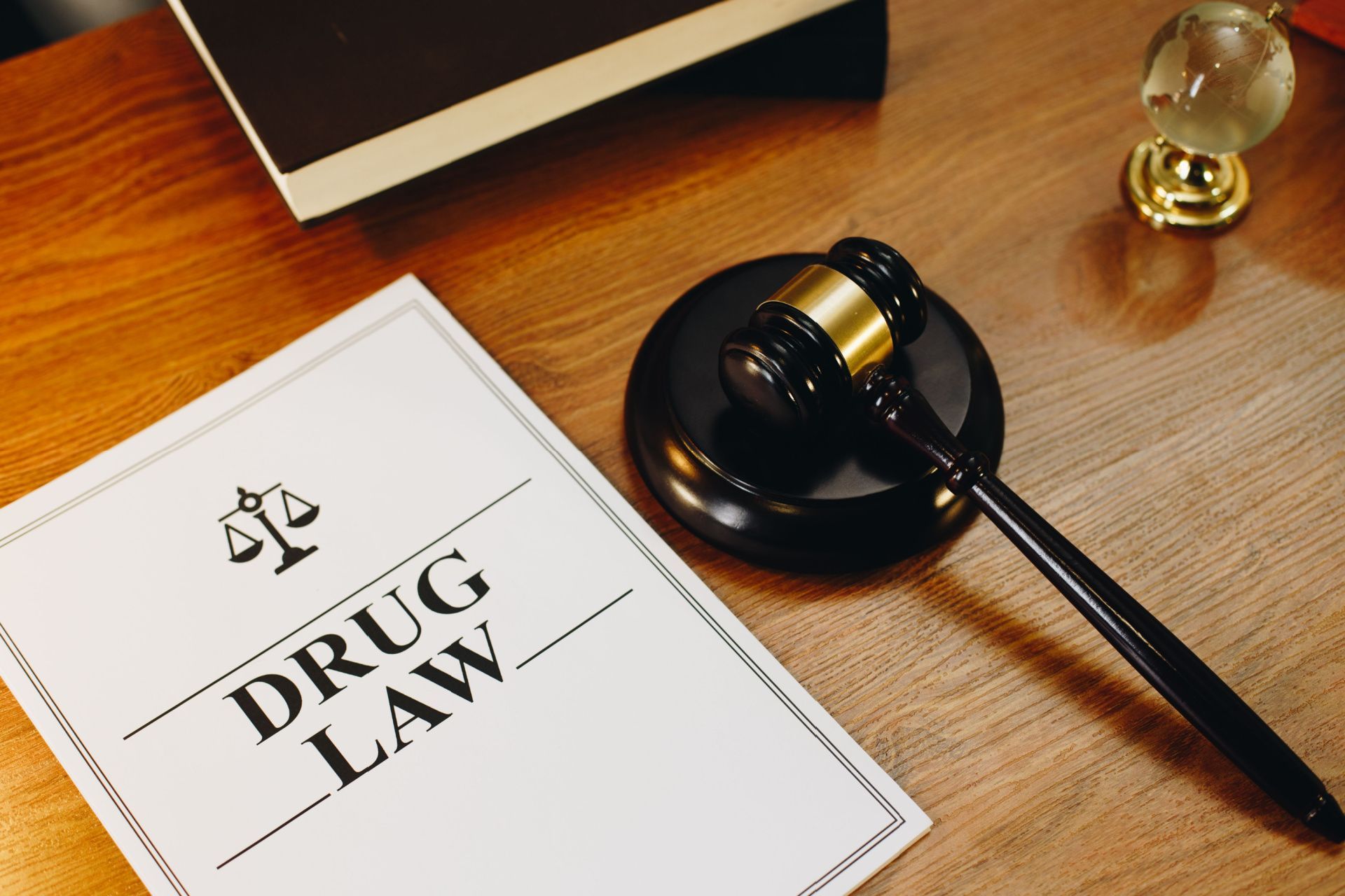 a judge 's gavel is sitting on top of a piece of paper that says drug law .