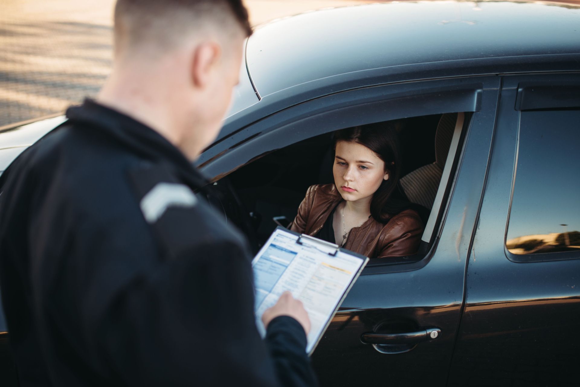 a police officer is talking to a woman in a car .