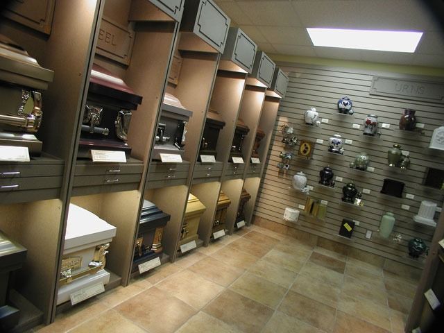Small storage room with shelves of boxes and supplies along one wall and hanging hardware on the other.