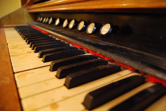 Close-up of a piano keyboard with black and white keys and control knobs above it