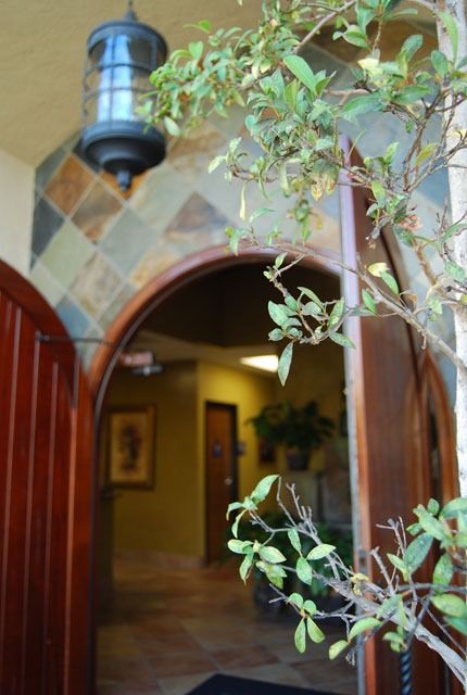 Arched doorway with hanging lantern and leafy plant framing a warmly lit hallway