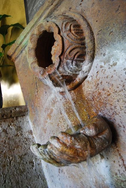 Rusty metal face sculpture with a hollow eye and carved mouth detail