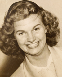 Smiling woman with wavy hair in a sepia-toned portrait.