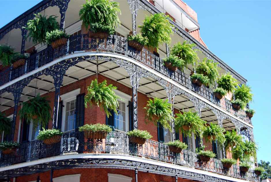 A building with a balcony filled with potted plants