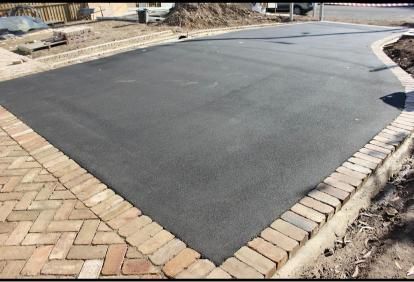 Black Asphalt Driveway With Bricks on the Side of It — JP Civilworx Pty Ltd in Taree, NSW