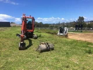 Small Excavator is Sitting in the Middle of a Grassy Field — JP Civilworx Pty Ltd in Maitland, NSW
