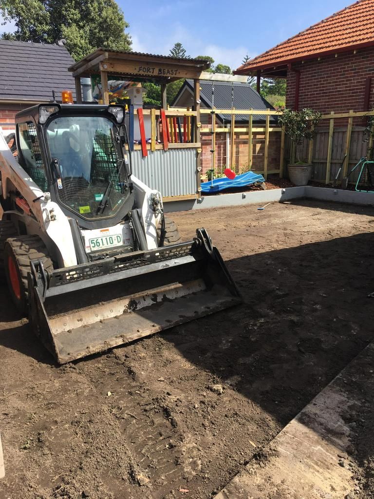 Bobcat is Sitting in the Dirt in Front of a House — JP Civilworx Pty Ltd in Taree, NSW