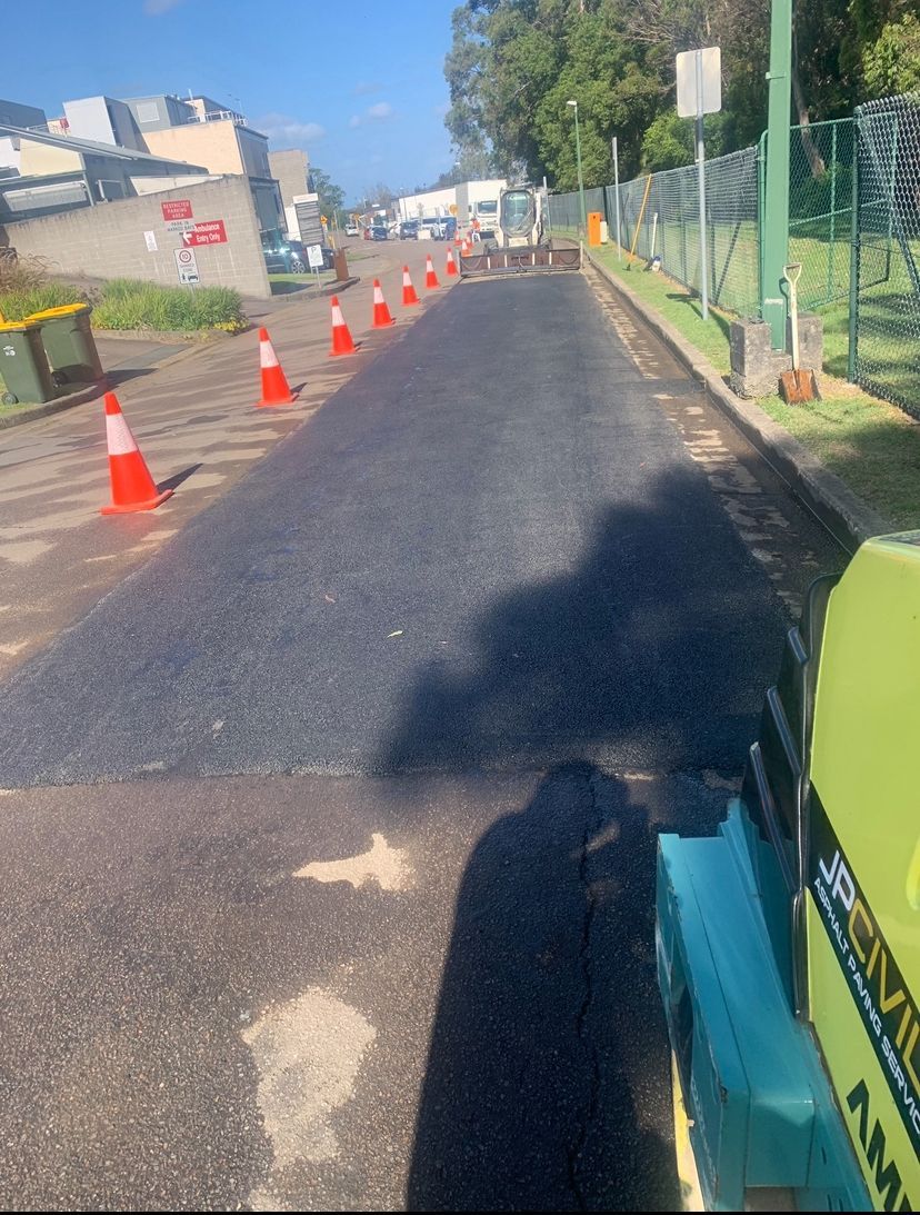 Bobcat is Parked In A Carpark In Front  Of A Building — JP Civilworx Pty Ltd in Eraring, NSW
