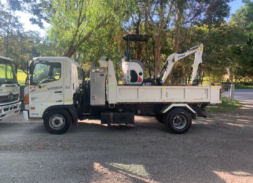 Construction Truck is Parked on the Side of the Road Next to Some Trees — JP Civilworx Pty Ltd in Eraring, NSW