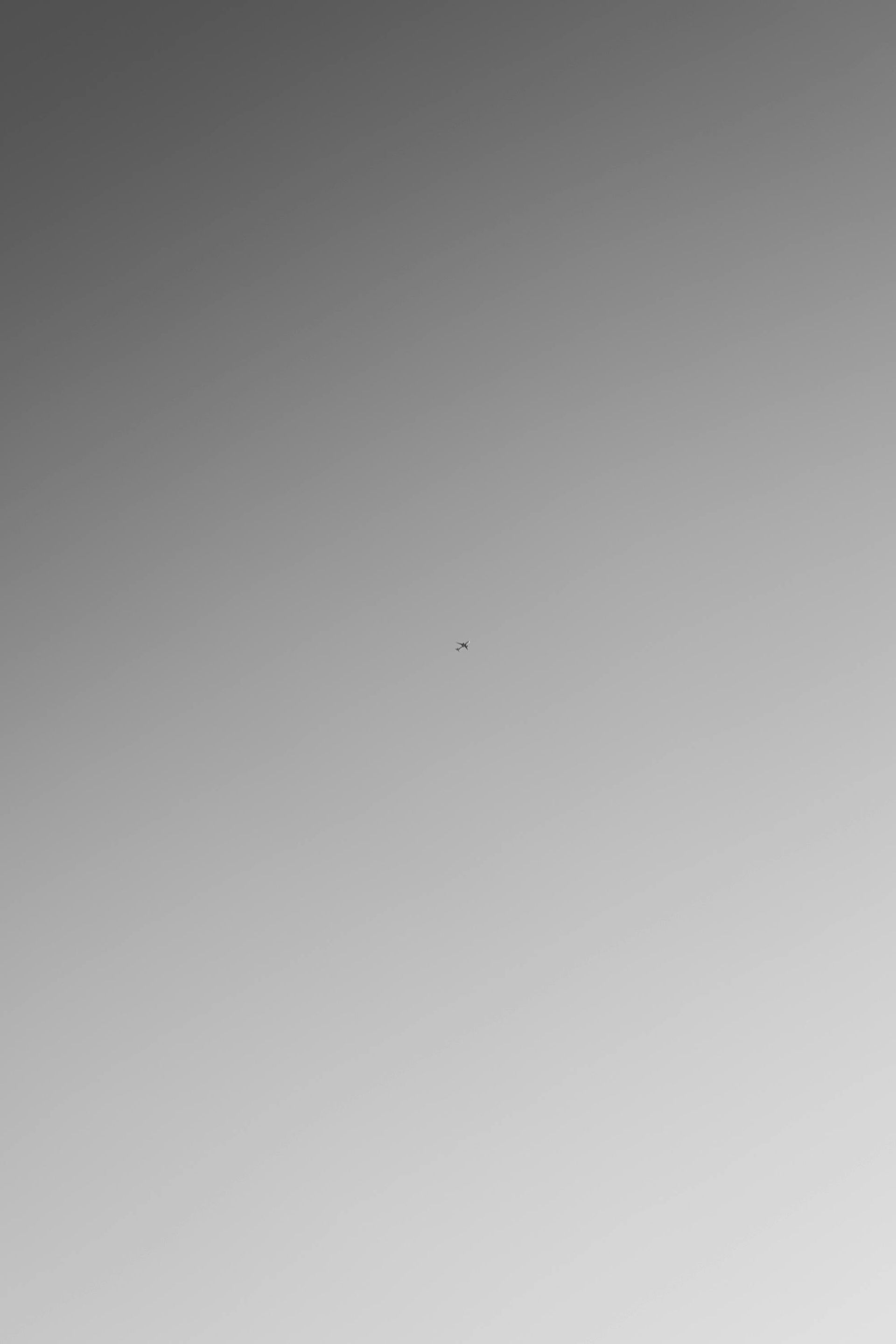 Fondo degradado gris con un pequeño punto oscuro en el centro.