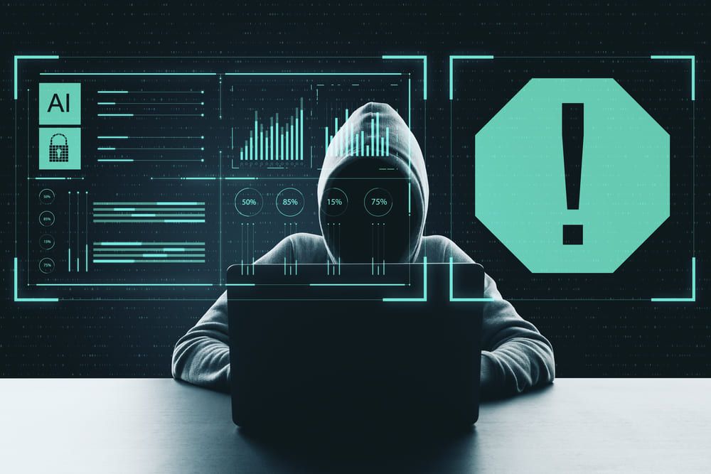 Hooded person at a laptop, with data visualizations and an alert symbol.