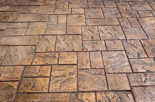 Tan textured stone pavers in shades of tan and brown, arranged in a patterned patio surface