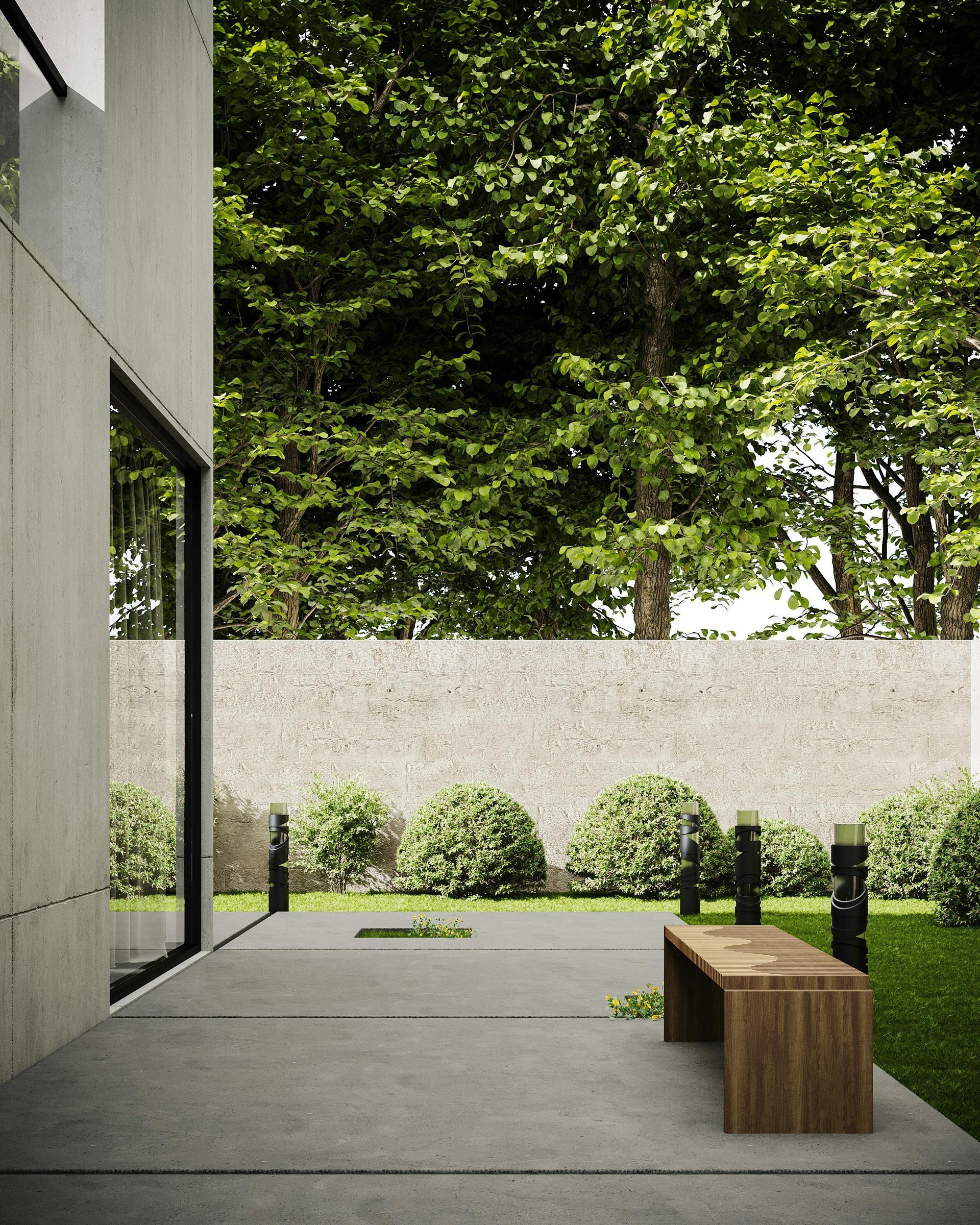 Modern courtyard with concrete walls, leafy trees, trimmed shrubs, and a wooden bench on a gray patio.