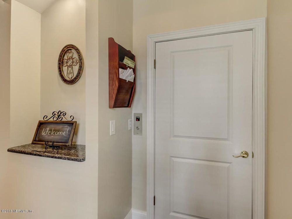 Hallway with a small marble shelf, door, and mail organizer.