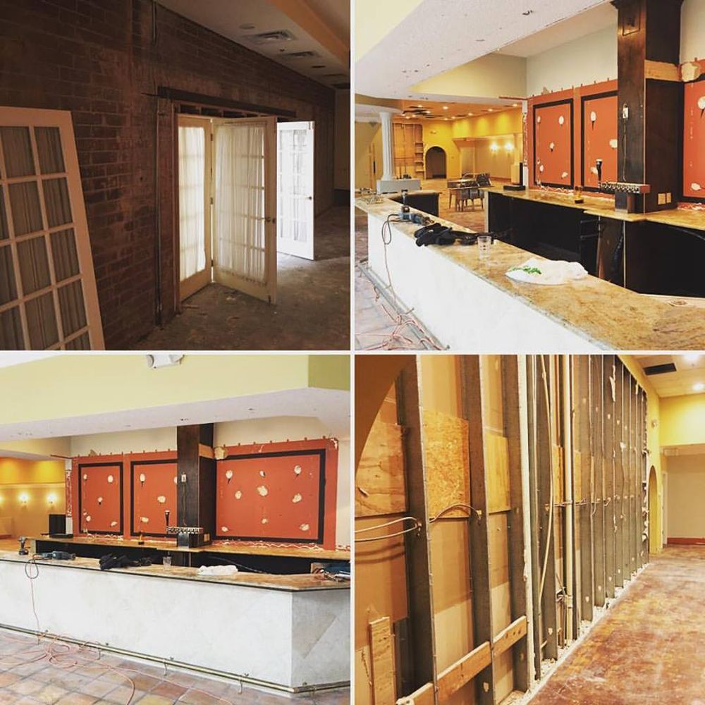 Construction site: restaurant interior under renovation, walls partially exposed, bar area being built.
