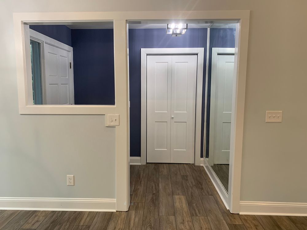 Interior with a blue accent wall and white trim. A doorway leads to a hallway and closet.