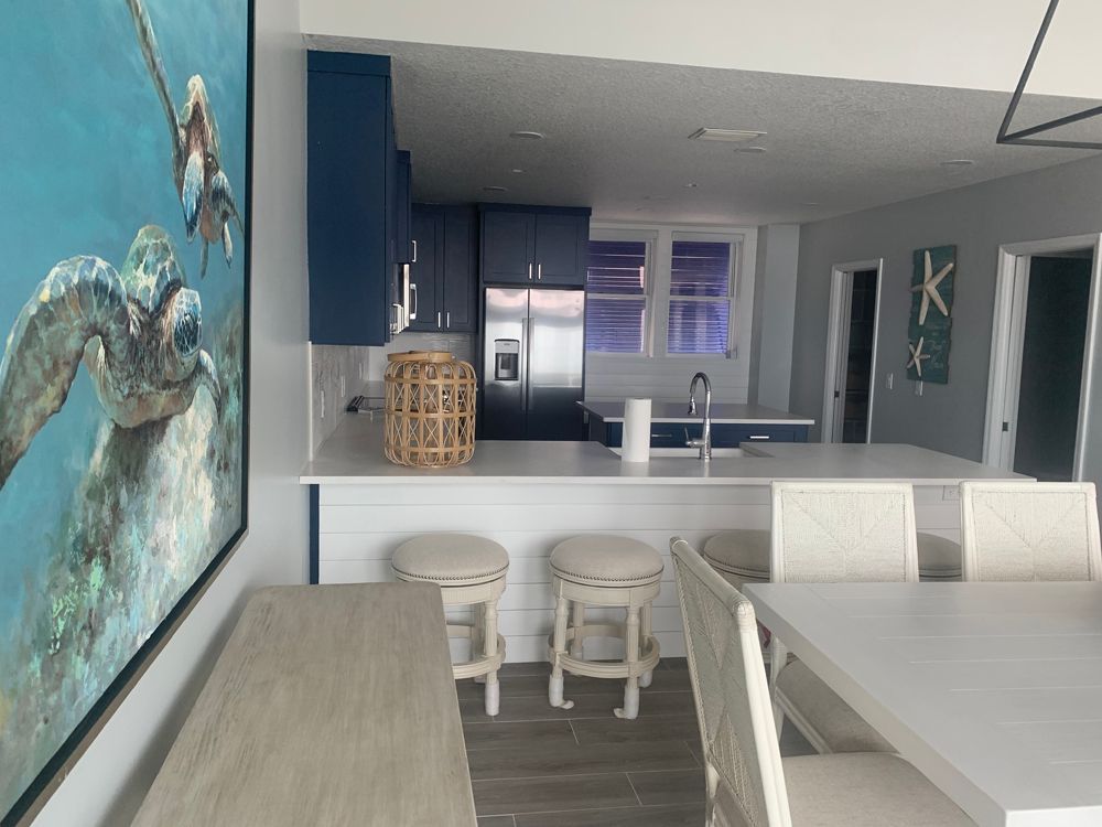 Kitchen with blue cabinets, white counters, and coastal decor.