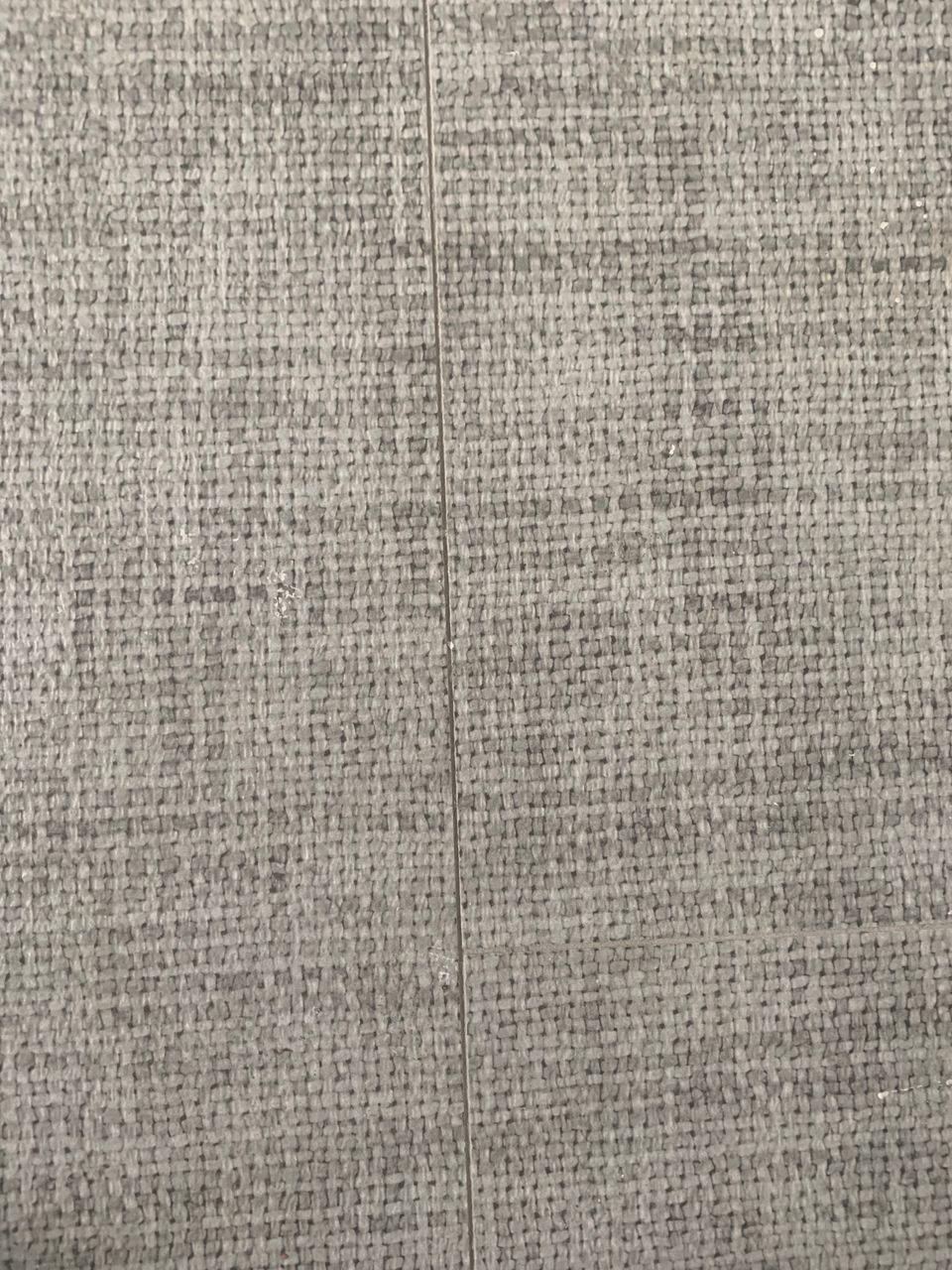 Gray textured tile flooring with vertical seam.