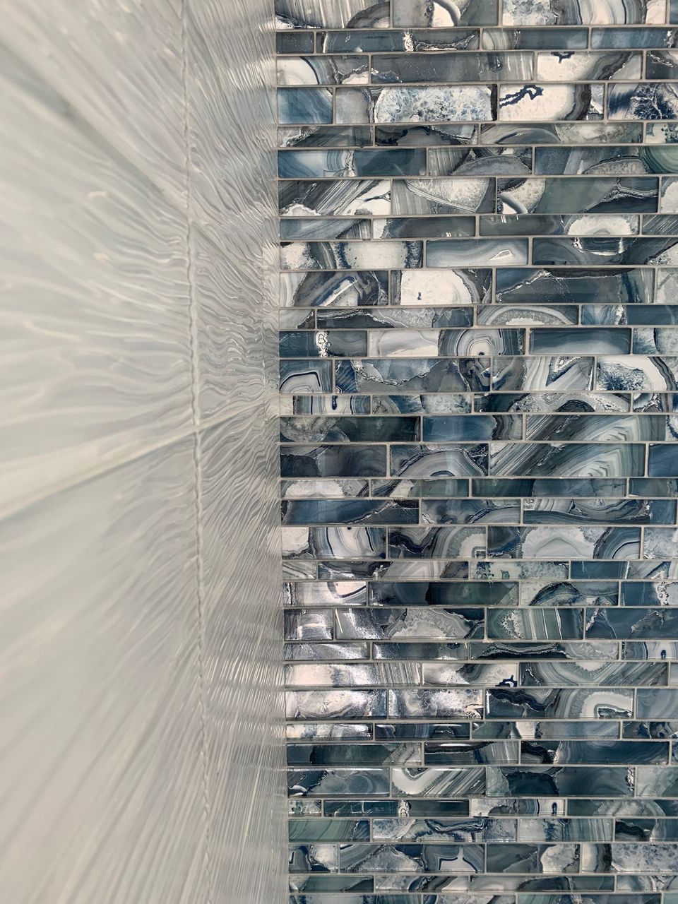 Wall with white and blue marbled tiles, split vertically.