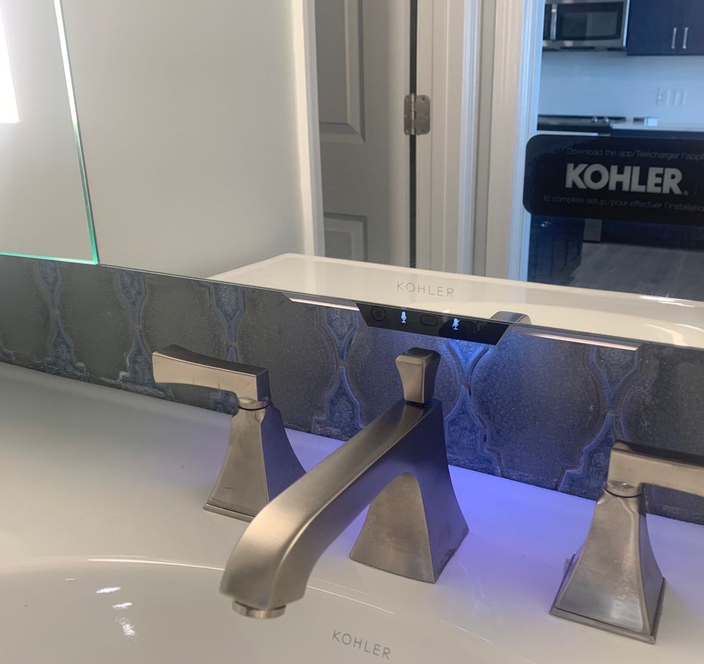 Silver faucet on white sink with a decorative backsplash. 