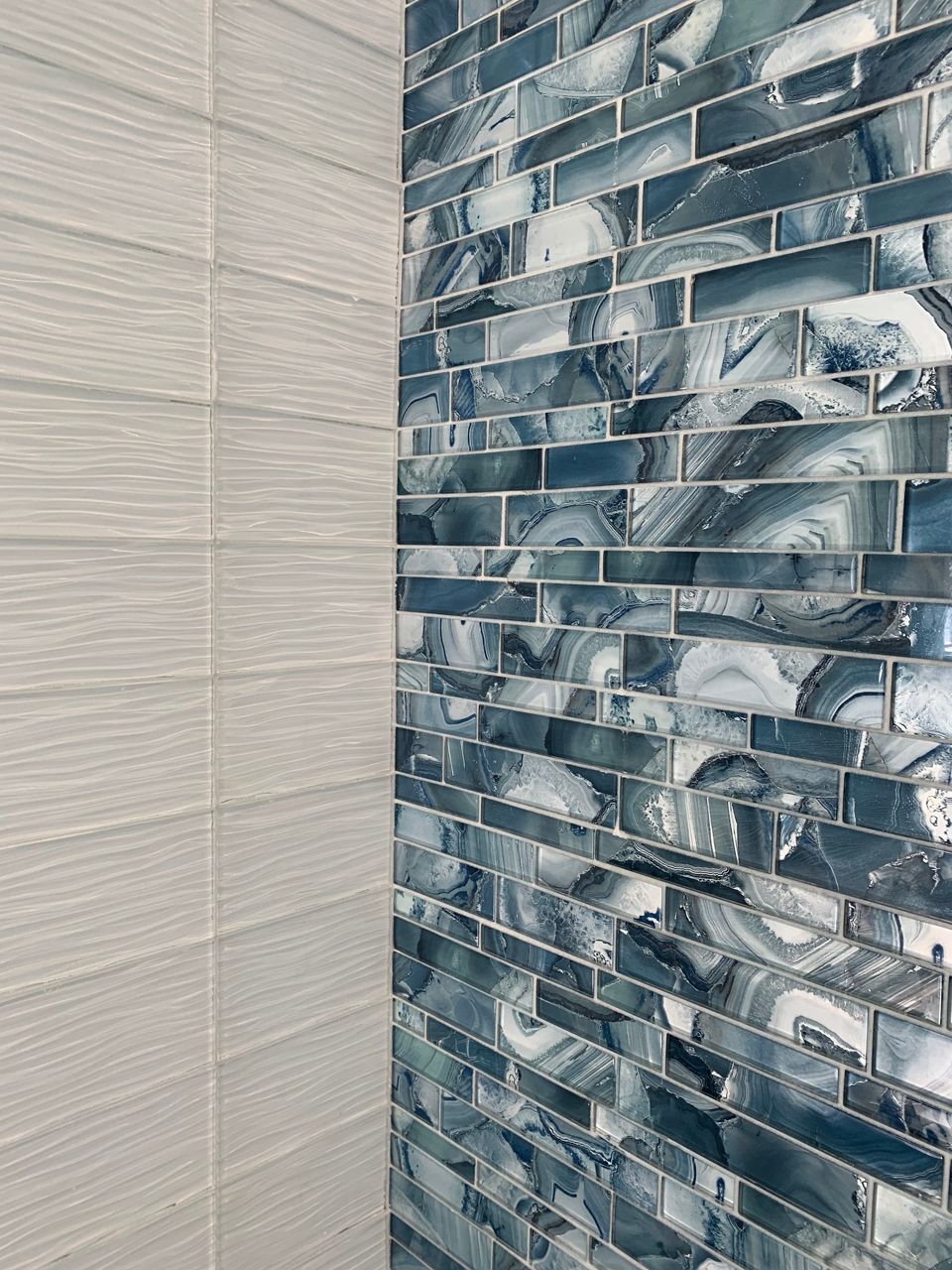 White and blue tiled bathroom corner. The blue tile has a marbled design.