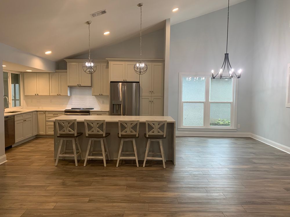 Modern kitchen with island, countertops, pendant lights, and wood flooring.