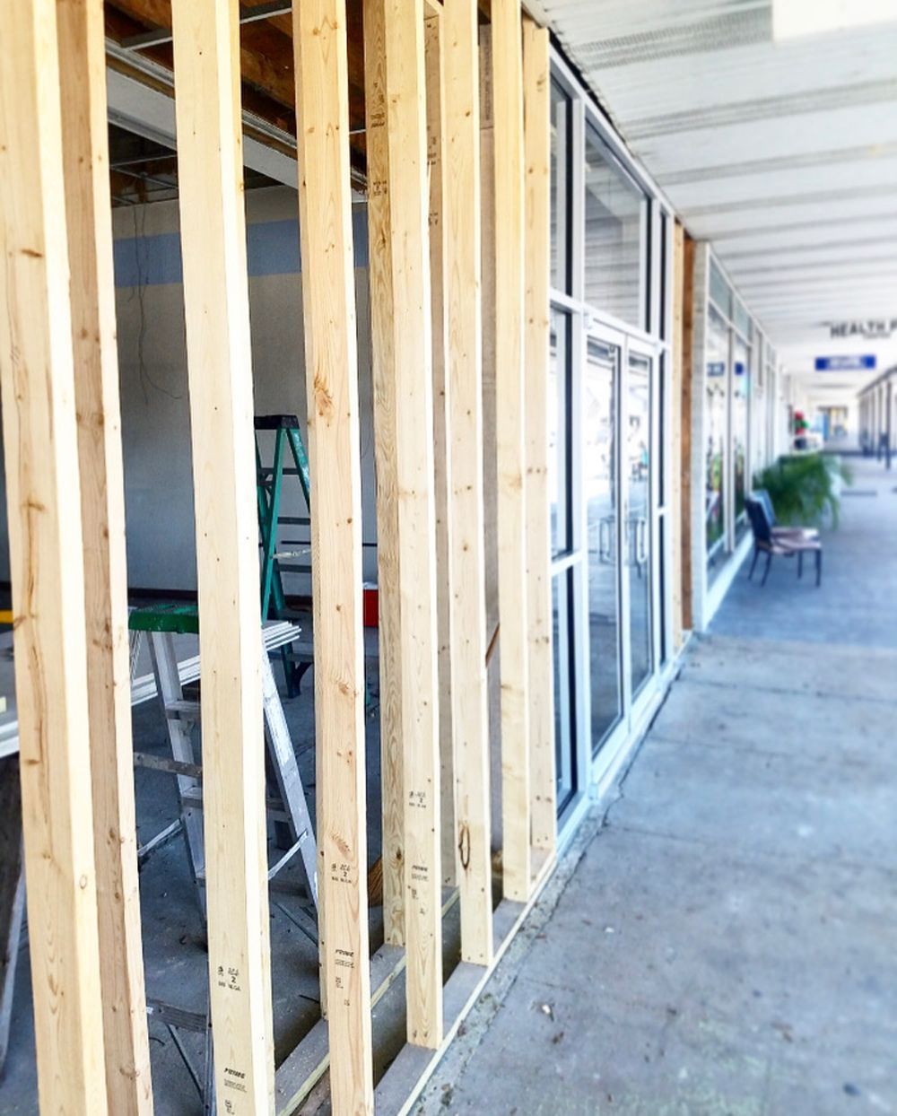 Wooden wall frame construction with glass windows in a commercial building.