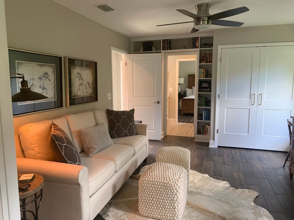 Cozy home office with sofa, bookshelves, and a cowhide rug.