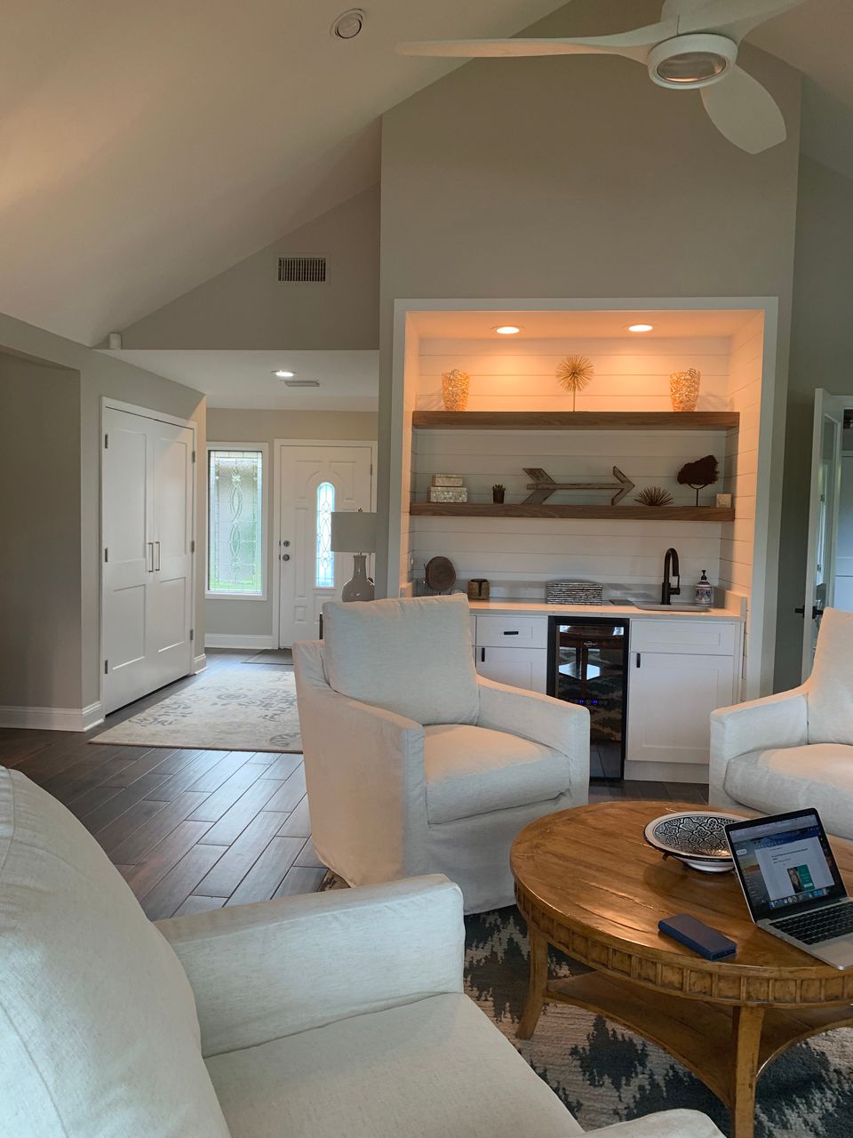 Living room with white furniture, a built-in bar, and dark wood floors.