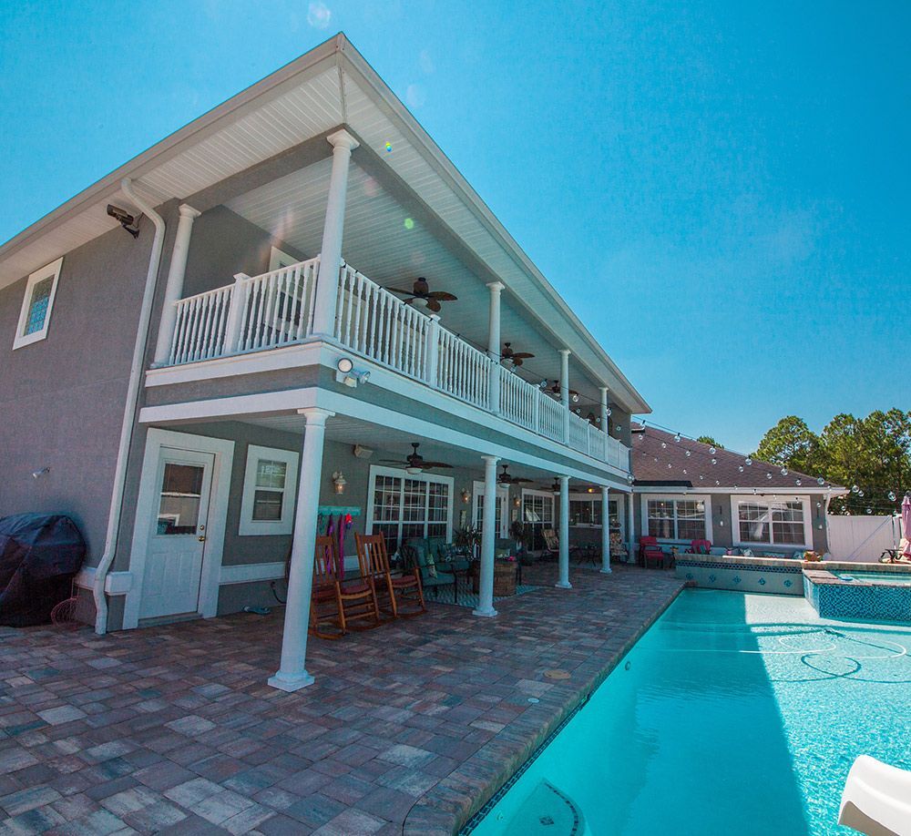 Wooden deck, angled, with french doors, tan walls, and brick patio.