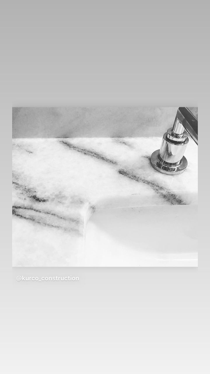 Marble sink countertop with chrome faucet in bathroom.