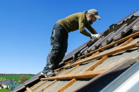 worker in the roof installing the tile