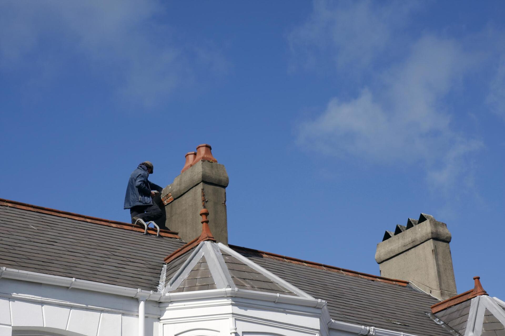worker in the roof checking the chimney