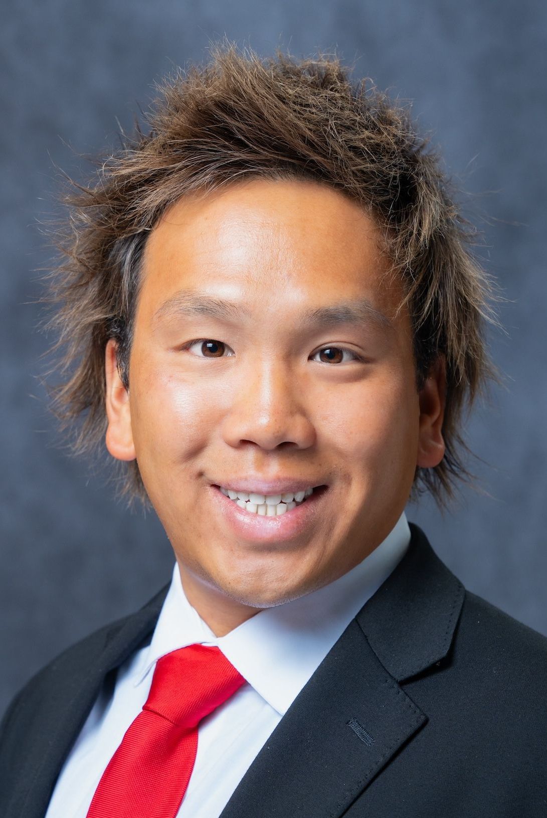 Cory Nguyen A man in a suit and tie is smiling for the camera.