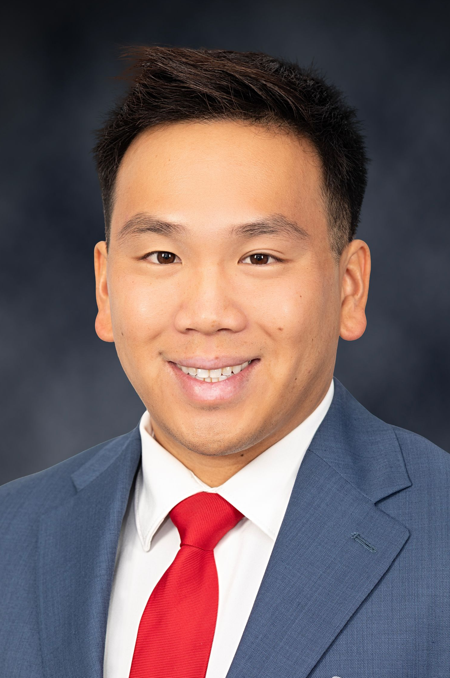 Cory Nguyen A man in a suit and tie is smiling for the camera.