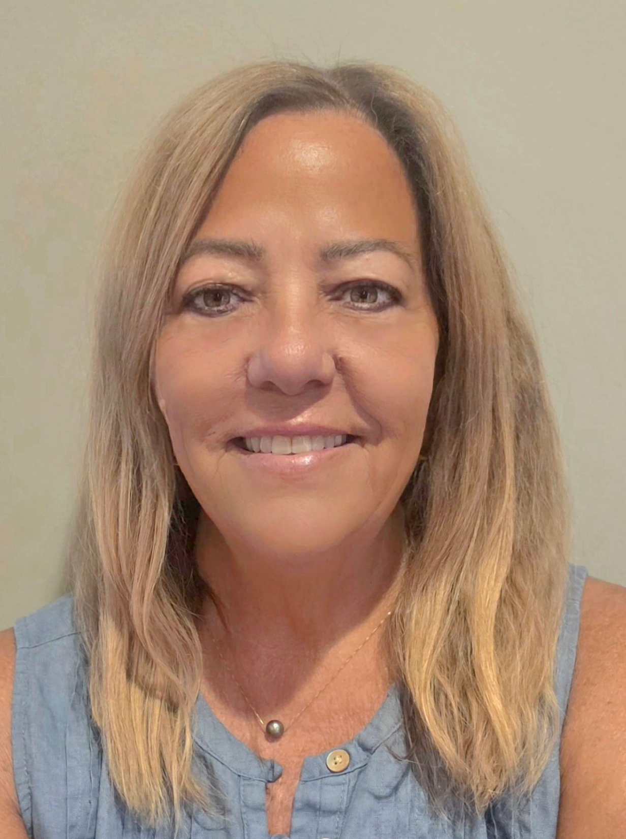 Leigh Ann Gilmore Smiling woman with shoulder-length blonde hair wearing a light blue sleeveless top against a plain background