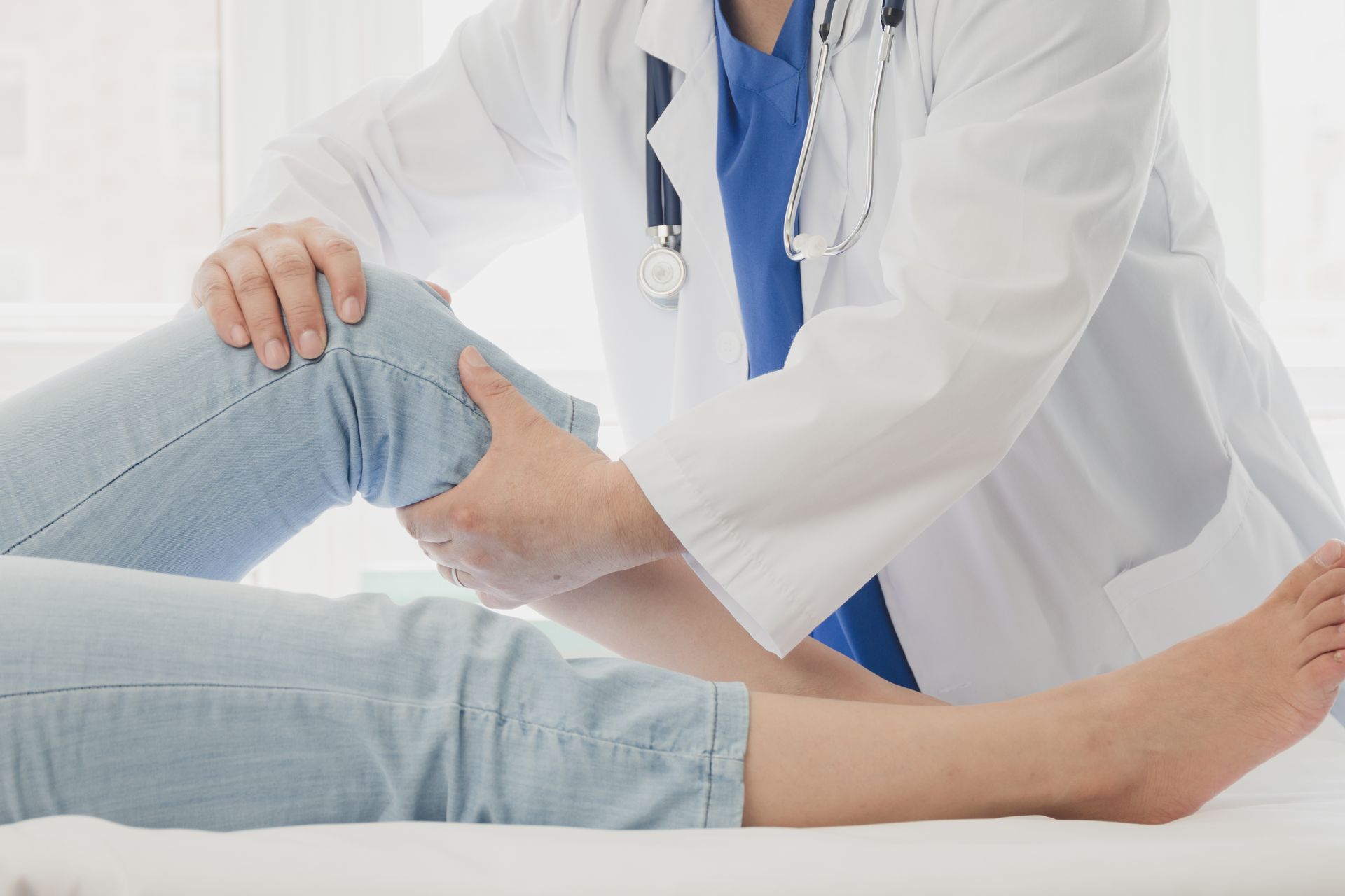 Doctor examining a patient’s knee on a exam table