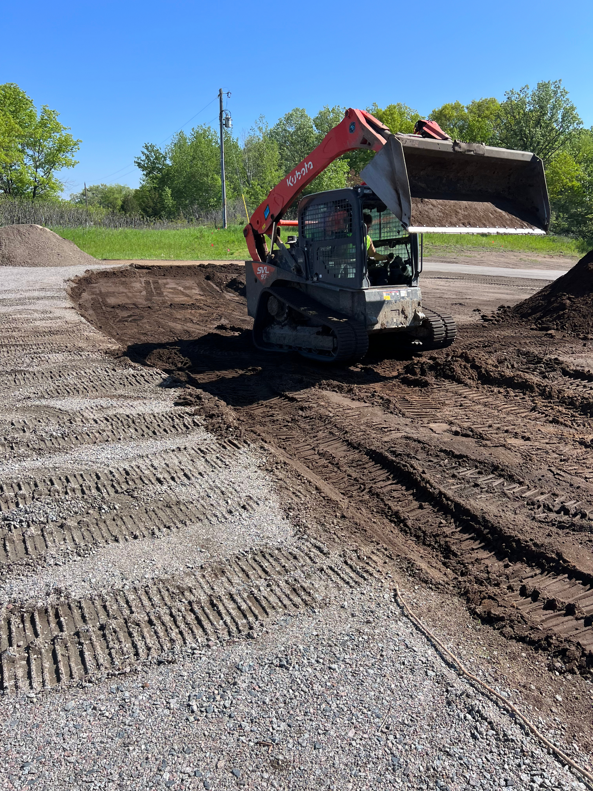 A dirt road with a bulldozer on the side of it.