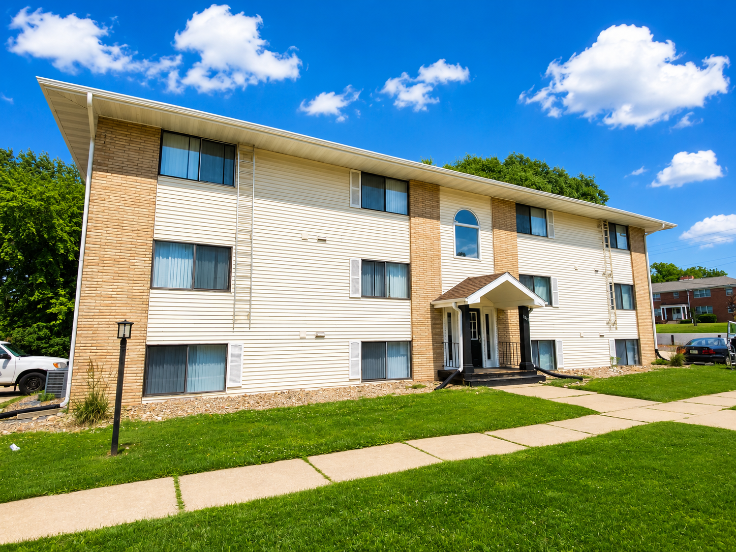 Apartment building with a steep triangular entrance, brown siding, and a central walkway