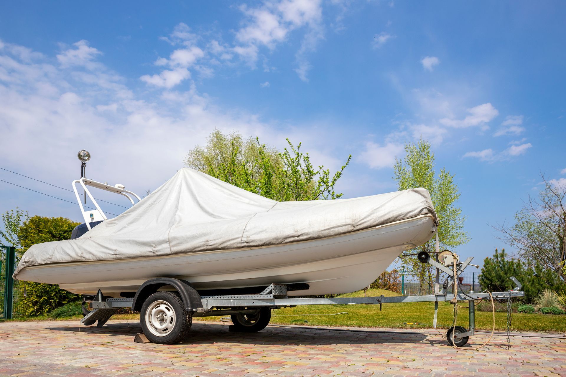 Custom tarp system fitted over a boat on a trailer for all weather protection.