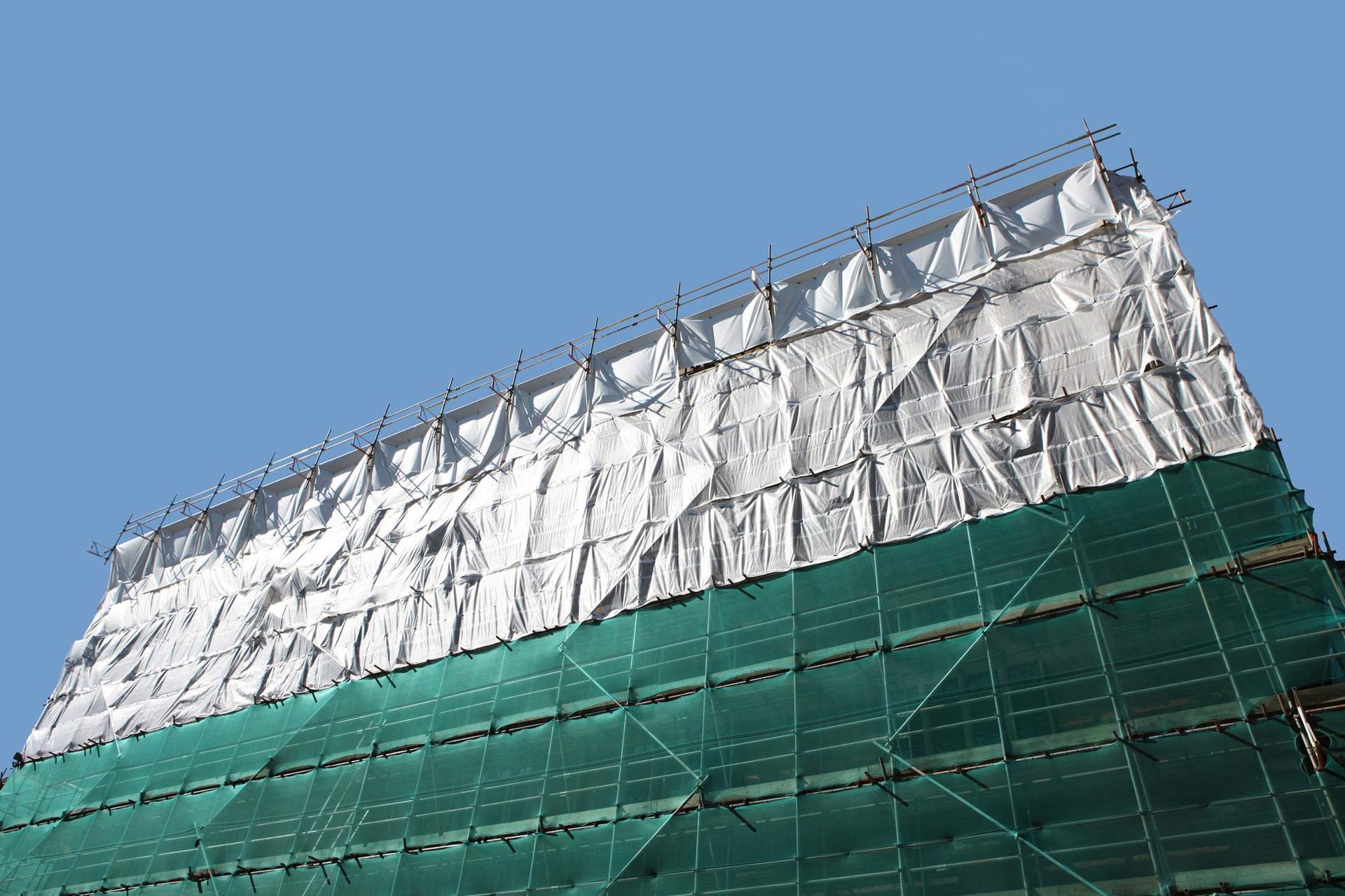 Protective industrial tarp cover and scaffolding on building restoration.