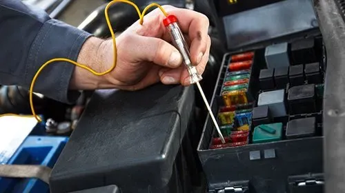 Electrical services image showing a technician testing various fuses at the automotive fusebox