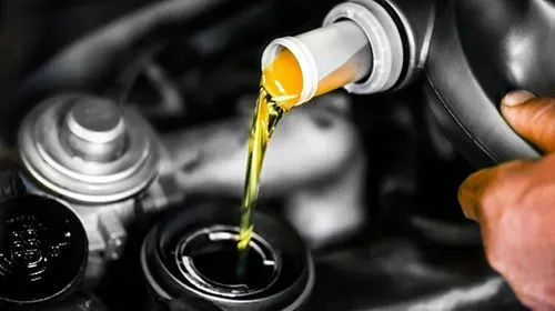 image showing technician pouring fluid into engine reservoir