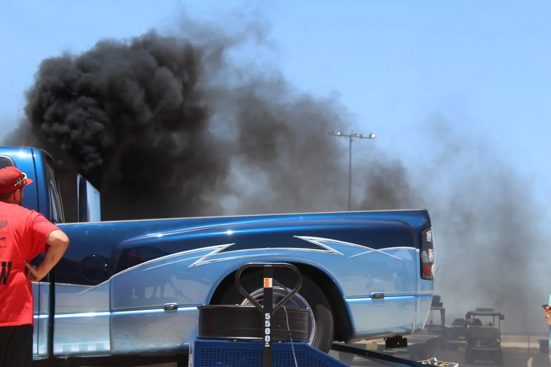 Dynamo image showing a car testing outdoor setup with smoke from spinning tires