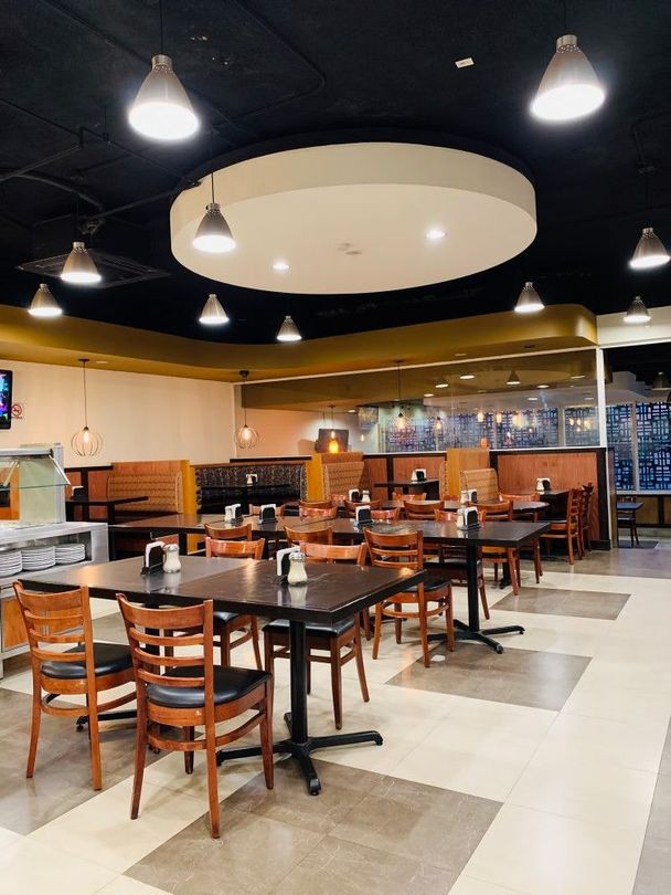 A restaurant with tables and chairs and a ceiling light